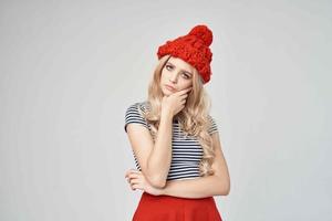 ziemlich Frau im ein gestreift T-Shirt rot Hut posieren Studio foto