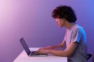 Kerl Cyberspace spielen mit im Vorderseite von ein Laptop violett Hintergrund foto