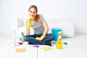 Reinigung Dame Sitzung auf das Fußboden Reinigung liefert Reinigung Haus Innere foto