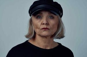 Alten Frau im ein schwarz Hut Mode Nahansicht Licht Hintergrund foto