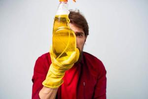 Mann im Gelb Handschuhe Waschmittel Reinigung Fachmann abgeschnitten Aussicht von Hausarbeit Lebensstil foto