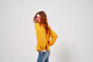 ziemlich Frau im ein Gelb Sweatshirt Frisur posieren Studio Spaß Modell- foto