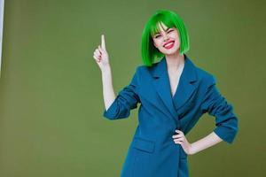 ziemlich jung weiblich tragen ein Grün Perücke Blau Jacke posieren Farbe Hintergrund unverändert foto