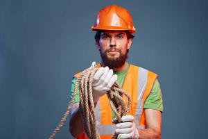 ein Arbeiten Mann im ein Orange Farbe Seil im das Hände von ein Konstruktion Fachmann foto