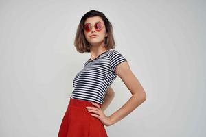 Frau tragen Sonnenbrille rot Rock Straße Mode isoliert Hintergrund foto