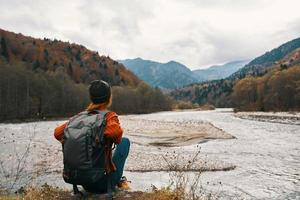 Reisender im das Herbst im das Berge im Natur auf das Banken von das Fluss foto