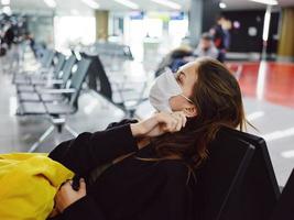 Frau im medizinisch Maske Flughafen Ferien warten zum Flug foto