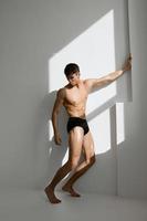 Bodybuilder mit ein gepumpt oben nackt Körper im schwarz Höschen basierend Studio foto