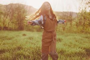 ein Frau Laufen durch ein Feld auf ein Sommer- Tag mit lange fließend Haar im das Strahlen von das Rahmen Sonne. das Konzept von Freiheit und Harmonie mit Natur foto