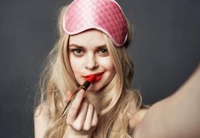 sexy blond Frau mit rot Lippenstift Emotionen und Rosa Maske auf ihr Gesicht foto
