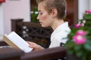 Schüler mit ein Buch im seine Hände lesen gehen im das frisch Luft Lebensstil foto