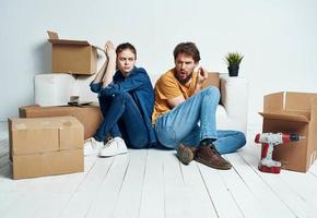 ein Mann und ein Frau mit Kisten sind ziehen um. Also, ein Wohnung ist Sein renoviert durch ein Familie foto