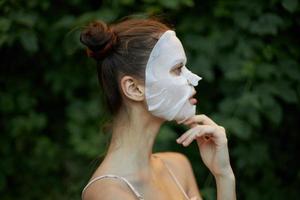 Porträt von ein Frau Anti-Falten Maske Haut Pflege Grün Blätter im das Hintergrund foto