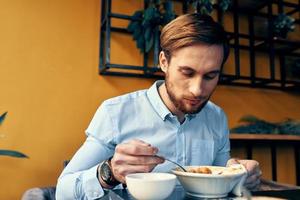 Geschäft Mann im Blau Hemd haben Mittagessen beim ein Cafe Tabelle foto