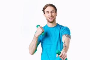 Mann im Blau T-Shirt halten Hanteln Fitness Übung foto