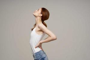 Frau im Weiß T-Shirt zurück Schmerzen Gesundheit Probleme Osteoporose Studio Behandlung foto