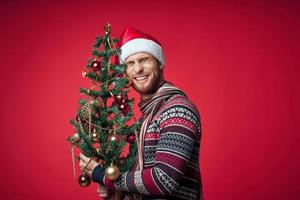Mann im ein Sweatshirt Weihnachten Baum Spielzeuge Dekoration foto