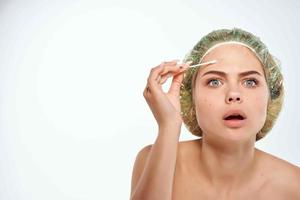 Frau mit nackt Schultern entfernt Pickel auf ihr Stirn Dermatologie foto