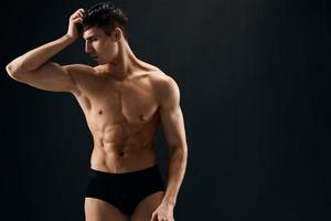 attraktiv männlich Athlet im dunkel kurze Hose Muskeln posieren isoliert Hintergrund foto
