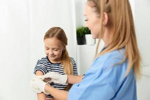 weiblich Arzt im Blau Mantel Medizin Behandlung Mädchen covid Impfung foto