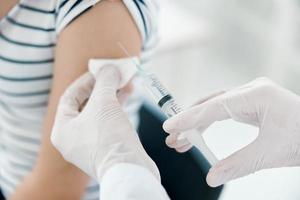 männlich Arzt Injektionen in Patienten Arm Nahansicht covid Impfung foto