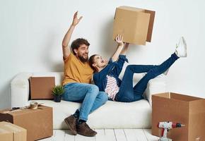 Familie jung Paar auf das Couch Spaß ziehen um Kisten mit Dinge foto