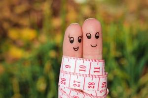 Finger Kunst von ein glücklich Paar mit Meter. das Konzept von verlieren Gewicht zusammen. foto