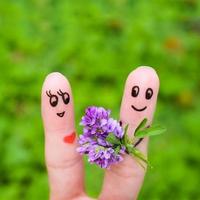 Finger Kunst von ein glücklich Paar. Mann ist geben Blumen zu ein Frau. foto