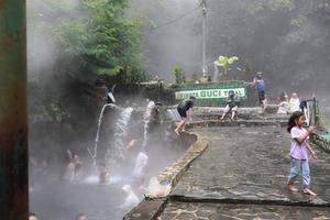 tegal, Januar 2023. Foto von beschäftigt Besucher entspannend und genießen das Guci heiß Frühling Bad.