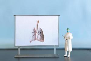 Miniatur Personen. ein Arzt untersucht Lungenentzündung im das Bild, ein Atemwege Krankheit. foto