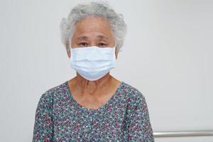 asiatische ältere patientin, die eine maske zum schutz des covid-19-coronavirus trägt. foto
