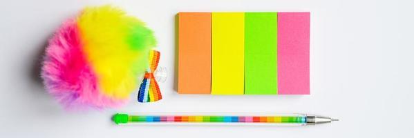 mehrfarbige Aufkleber und ein Stift auf weißem Hintergrund
