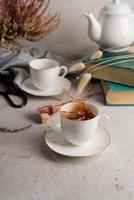Stillleben mit Tee aus Teetasse, Büchern und Blumen foto