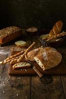 Vielzahl von hausgemachten Broten auf dunklem rustikalem Hintergrund foto