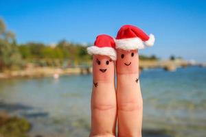 Finger Kunst von glücklich Paar im Weihnachten Hüte ruhen auf das Meer foto