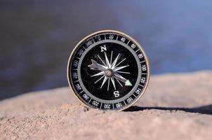 schwarz Kompass auf ein Felsen foto