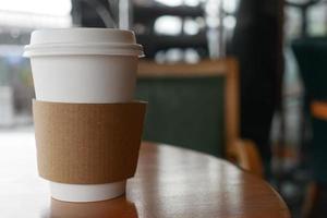 Nehmen Sie Kaffeetasse aus Papier o auf dem Café-Tisch mit foto
