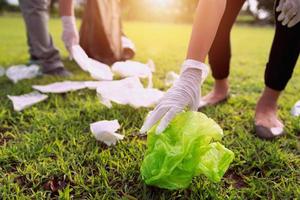 Mutter und Kinder behalten Müll Plastik Flasche in schwarz Tasche beim Park im Morgen Licht foto