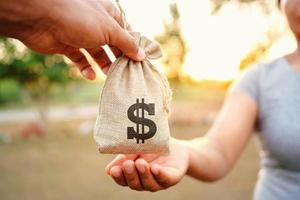 Konzept Finanzen Buchhaltung. Hand geben Geld Tasche zum Frau foto