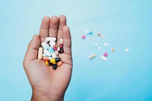 Medizin und Tabletten im Hand auf Blau Hintergrund. Gesundheit Pflege Konzept foto