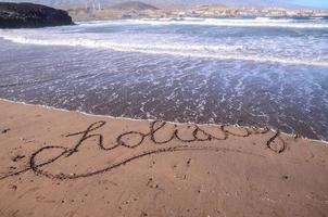 das Wort Urlaub geschrieben im das Sand foto