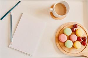 leeres Notizbuch mit Tasse Kaffee und Dessert auf dem Tisch