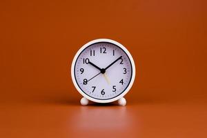 Weiß Uhr auf braun Hintergrund, Zeit Konzept Arbeiten mit Zeit Planung Zeit zum Leben foto