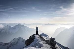 Mann Stehen auf das oben von ein schneebedeckt Berg Gipfel. Panorama- Aussicht foto