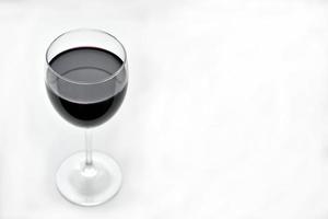 großes Glas Rotwein auf weißem Grund foto