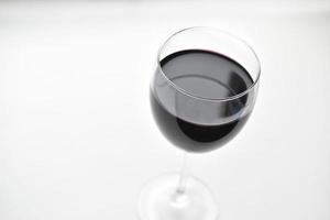 großes Glas Rotwein auf weißem Grund foto