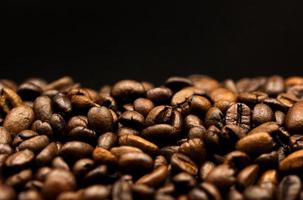 Espresso geröstet Kaffee Bohnen isoliert im schwarz Hintergrund schließen oben foto