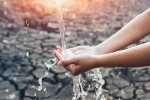 Wasser mit Hand mit Sonnenuntergang Hintergrund foto