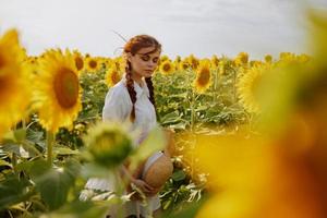 Frau mit Zöpfe suchen im das Sonnenblume Feld Landschaft foto