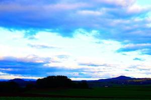 Dämmerung Wolken über dunkel Land foto